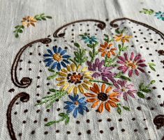 an embroidered piece of cloth with flowers on it