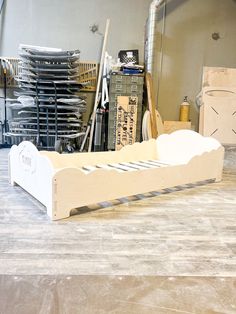 a wooden bed frame sitting on top of a hard wood floor next to stacks of boxes