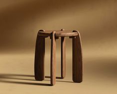 two wooden stools sitting next to each other on a brown surface with shadows from the floor