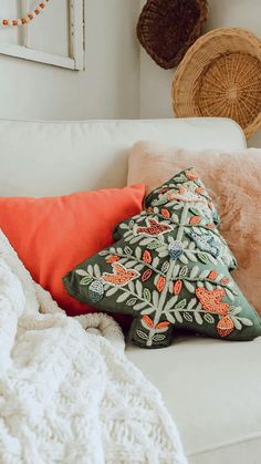 a white couch topped with pillows and blankets