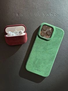 an iphone case and earbuds are laying next to each other on a table