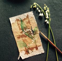 an old piece of paper sitting on top of a table next to a flower vase