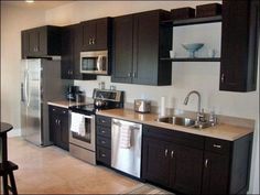 a kitchen with brown cabinets and stainless steel appliances