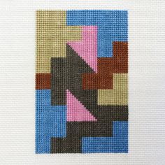 a cross stitch pattern with different colors and shapes on the side of a white wall