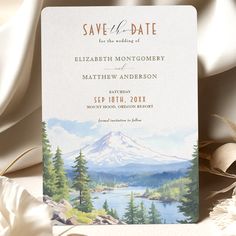 a save the date card with a mountain scene on it