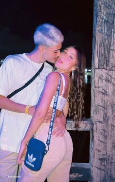 a man and woman kissing each other in front of a wooden fence with the caption'me dexa dera ser lougo de amor '