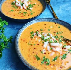 two bowls filled with soup and garnished with shrimp