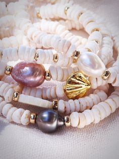 Choose one or all. These stretchy natural white puka shell bracelets evoke visions of Hawaii's white sands and soothing shores. Super rare tiny puka shells make these bracelets one of a kind. Stack these gold seashell bracelets high and you'll be ready for your tropical escape. ✦ CHOICES DETAILED BELOW ✦ ✧ Style A: Natural White Baroque Freshwater Pearl ✧ Style B: Natural Mauve Pink Freshwater Pearl ✧ Style C: Natural 8-10mm Baroque Tahitian Pearl ✧ Style D: Gold Filled Beads ✧ Style E: Gold Pla Adjustable White Coastal Beaded Bracelets, White Round Beads Ocean-inspired Bracelets, White Stackable Bracelets For Beach, White Coastal Beaded Bracelets For Vacation, Adjustable White Shell With Ocean-inspired Style, Spiritual White Stretch Bracelet For Beach, White Coastal Style Bracelet For Gift, White Ocean-inspired Beaded Bracelets, White Ocean-inspired Round Bead Bracelets