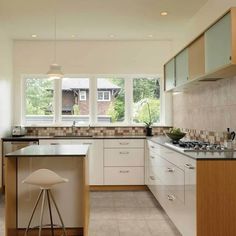 a kitchen with an island, sink and stove top oven in the middle of it