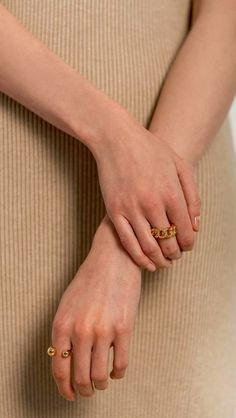 a woman's hand with two gold rings on her left and the other hand