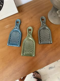 three ceramic graters sitting on top of a wooden table