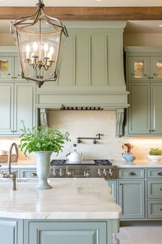 a kitchen with green cabinets and a chandelier