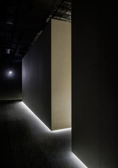 an empty room with lights on the floor and walls in front of it at night