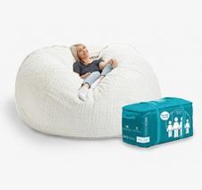 a woman laying on top of a white bean bag chair next to a blue tissue dispenser