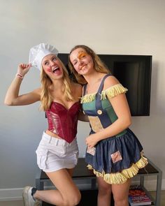 two women dressed in costumes posing for the camera