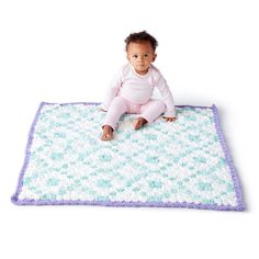 a baby sitting on top of a blue and white blanket with purple trimmings