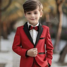 a young boy wearing a red suit and bow tie