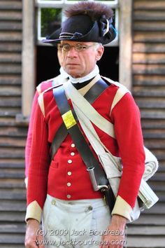 a man in uniform standing next to a building