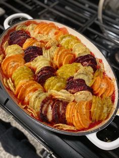 a casserole dish filled with different types of vegetables on top of an oven