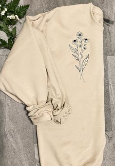 Welcome to Calvin's Street. You will love this long stem flower embroidered sweatshirt.  EMBROIDERY DESIGN   All designs are made with direct embroidery.  Design is embroidered on the left of the front chest.  SWEATSHIRT INFO 7.5 oz., 60/40 cotton/polyester Lined with fleece Unisex sizing SIZING Please look at the sizing chart in my product photos for measurements. If the size you need is sold out message me so I can check to see if my supplier offers/has your size! EMBROIDERY THREAD CARE 1. For best results, wash in warm water with a mild detergent. 2. Do not add bleaching agents such as chlorine, peroxide or sodium carbonate. 3. Do not line dry. Garments should be tumble dried at warm setting. 4. Never leave damp or wet embroidered articles folded or stuck together. 5. Never wring out an Embroidered Long Sleeve Sweatshirt For Spring, Spring Cotton Sweatshirt With Floral Embroidery, Floral Embroidery Cotton Sweatshirt For Spring, Spring Floral Embroidered Crew Neck Sweatshirt, Cotton Floral Embroidery Sweatshirt For Spring, Spring Long Sleeve Tops With Custom Embroidery, Spring Long Sleeve Sweatshirt With Floral Embroidery, Spring Embroidered Long Sleeve Sweatshirt, Spring Floral Embroidery Long Sleeve Sweatshirt