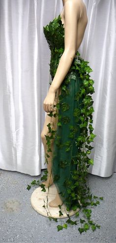 a mannequin is covered in green ivy