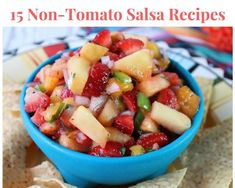 a blue bowl filled with fruit salsa next to tortilla chips