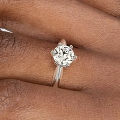 a woman's hand with a diamond ring on it