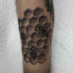 a man's leg with some bees and honeycombs tattoo on his legs