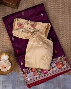 Recount the refinement of superiority with this Banarasi Wine Tifli work saree. The Lustrous wine body is embossed with beautiful tifli work multihued butta embraced into a selff border featuring gold zari floral vines perched with beautiful tifli florals and flanked by red selvedge for spellbinding appeal. a contrast cream padded-blouse with work hands is accompanied. Elegant Motif Blouse For Puja, Elegant Blouse With Motifs For Puja, Elegant Embroidered Pre-draped Saree For Puja, Designer Silk Blouse Piece With Motifs, Elegant Dola Silk Blouse Piece With Motifs, Festive Tissue Silk Blouse Piece With Motifs, Elegant Resham Embroidered Fabric For Puja, Elegant Resham Embroidery Fabric For Puja, Wedding Blouse In Banarasi Silk With Motifs