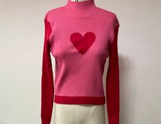 This sweater is a versatile and comfortable addition to any wardrobe. With long sleeves, a mock neck, and a casual pull-on closure, it provides warmth and protection from the cold while still allowing for breathability and flexibility. The sweet heart pattern adds a cute and feminine touch to the sweater, while the ribbed knitted striped design adds texture and visual interest. The contrast color patchwork adds a pop of color and contrast to the sweater, making it a great choice for those who wa Green Mint, Color Block Sweater, Design Color, Red Sweaters, Red Rose, Heart Design, Red Roses, Color Block, Color Design