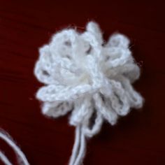 there is a white crochet flower on the table