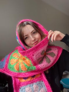 a woman wearing a pink crocheted scarf with flowers on the front and sides