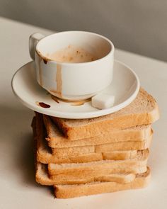 a stack of toasted bread with a cup of coffee sitting on top of it