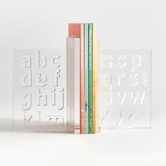 three clear books are stacked on top of each other, with the letters cut out