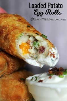 an egg roll being dipped with sour cream