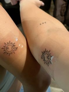 two people with sun and moon tattoos on their legs