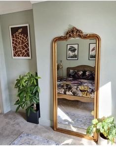 a bedroom with a large mirror on the wall next to a potted plant and bed