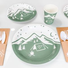 a table set with plates, napkins and utensils in the shape of mountains