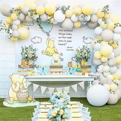 a winnie the pooh birthday party with balloons and decorations