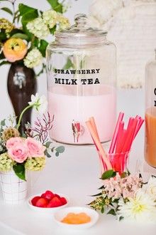 there is a jar with strawberries and milk on the table next to other items