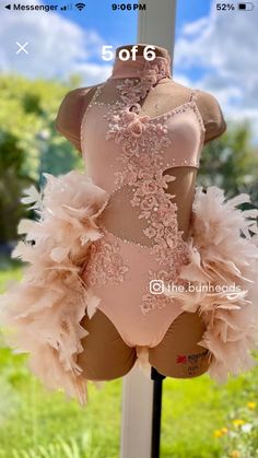 a mannequin wearing a pink bodysuit with feathers on it