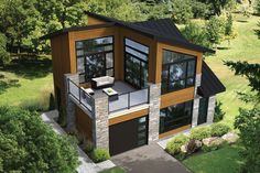 this is an aerial view of a modern house in the woods with lots of windows