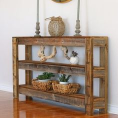 a wooden shelf with plants on it in front of a clock and wall hangings