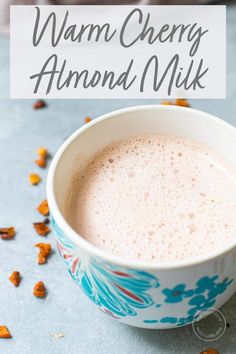 a cup of warm cherry almond milk with the text overlay reading warm cherry almond almond milk