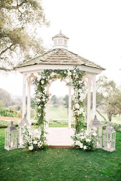 a white gazebo with flowers and candles on it