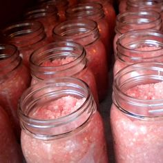 many jars filled with pink stuff sitting next to each other