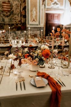 the table is set with silverware, flowers and candles for an elegant wedding reception