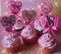 cupcakes decorated with pink and white frosting, topped with paper heart decorations