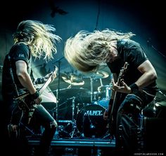 two people on stage with guitars and drums