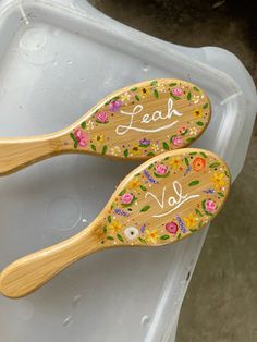 two wooden spoons decorated with flowers and the words lead v is for love on them